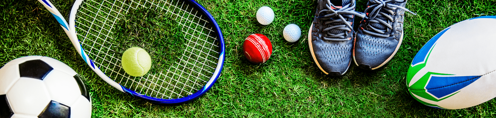 Equipamento desportivo variado sobre relvado: bola de futebol, raquete e bola de ténis, bolas de golfe, críquete, râguebi e sapatilhas de corrida.