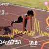 Mulher em posição de partida numa pista de atletismo ao ar livre, com sobreposição de elementos gráficos digitais como batimento cardíaco, distância percorrida, tempo e trajeto, representando monitorização de desempenho desportivo.