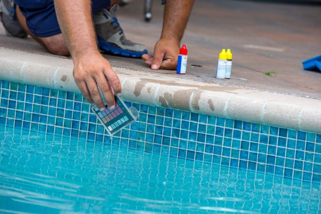 Gestor de piscinas realiza teste de pH na água da piscina como parte da manutenção e gestão eficiente, garantindo a segurança, qualidade e conformidade com a legislação.